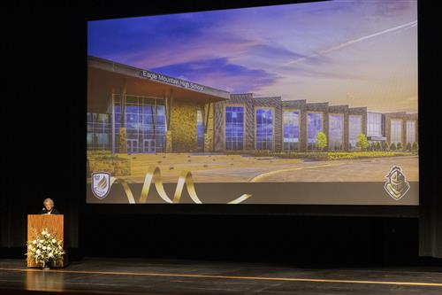 A woman in front of a large screen